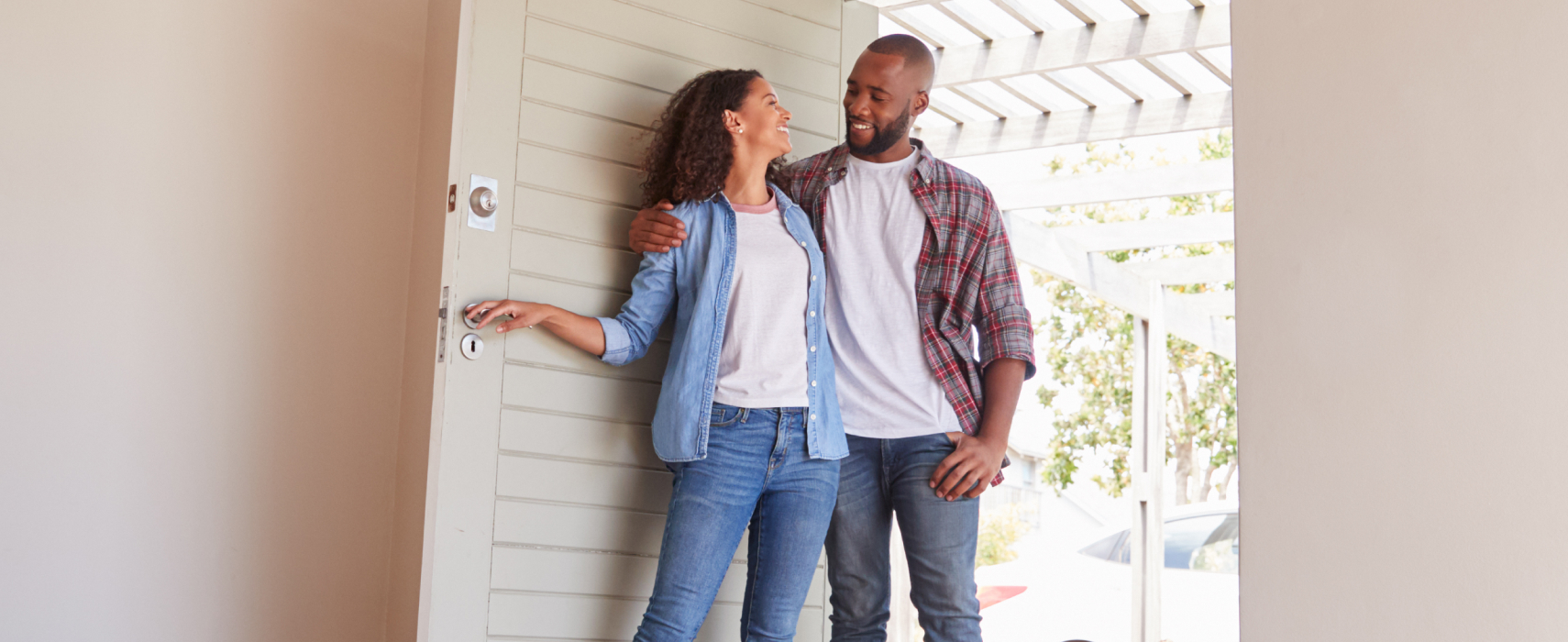 man and woman walking into a house