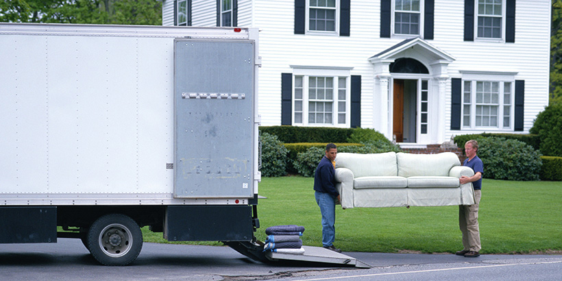 People loading furniture into a moving truck.