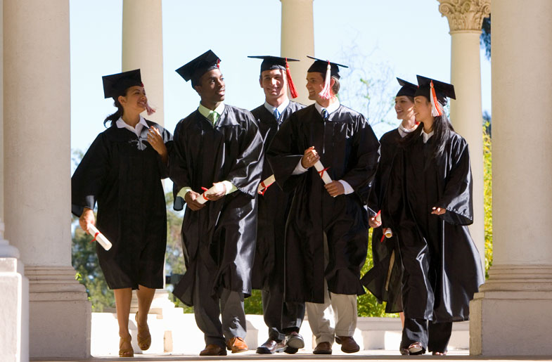 College graduates in caps and gowns carrying diplomas