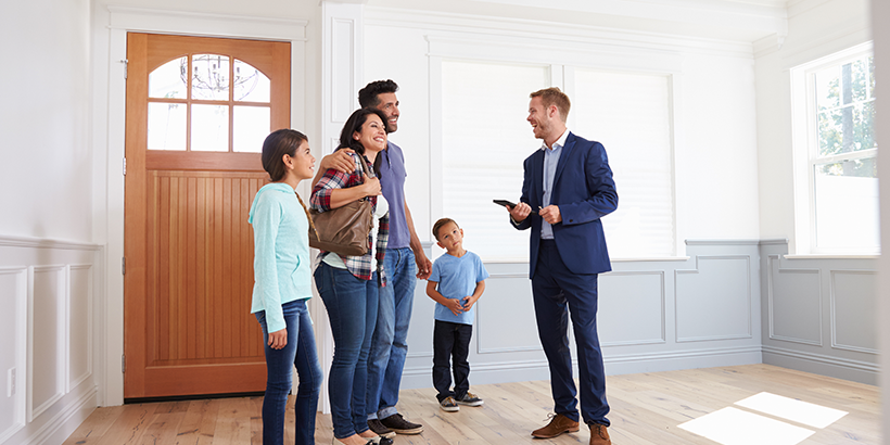 Man and family standing in the entry of a home