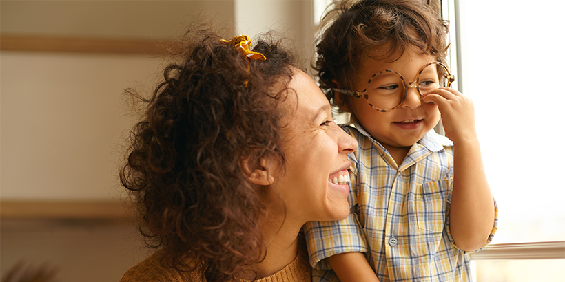 Parent holding child in front of a window