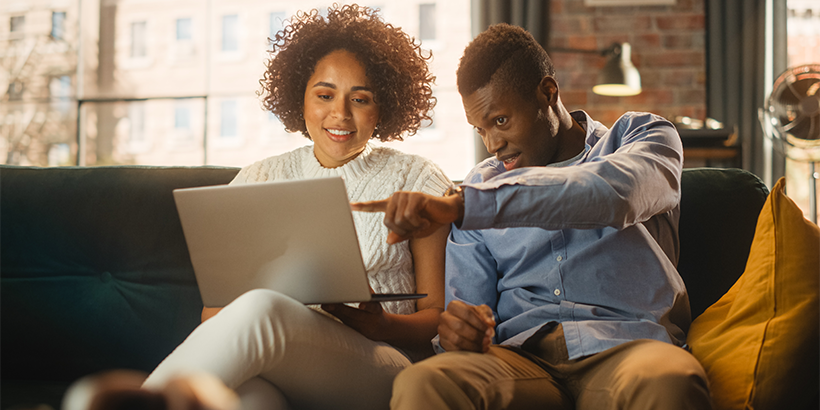 Couple looking at a laptop in their living room