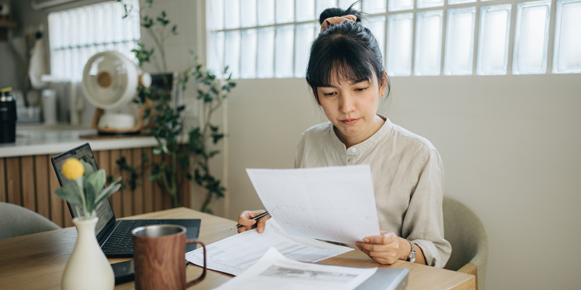 Person reviewing documents at kitchen table