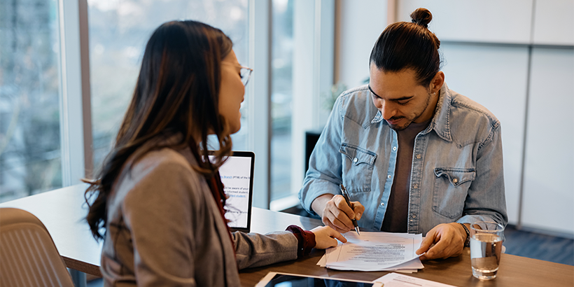 person filling out paperwork with lender