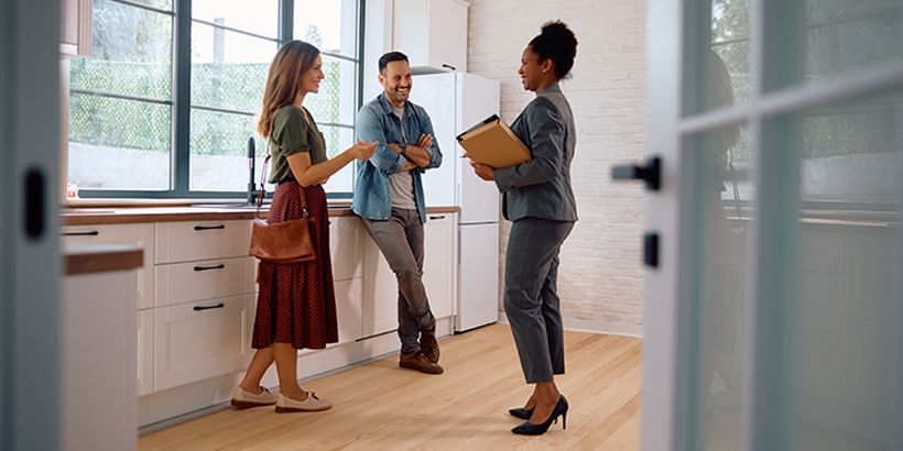 Couple chatting with real estate agent in a kitchen