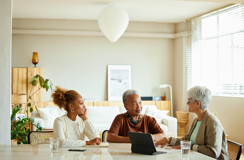 Two women meeting with their lender in an office