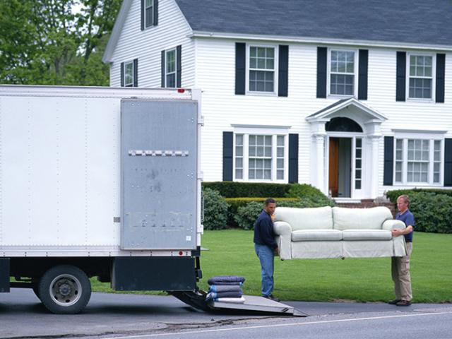 People loading furniture into a moving truck.