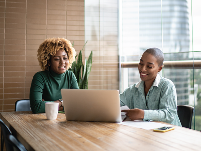 A homebuyer and lender looking at a laptop in a conference room