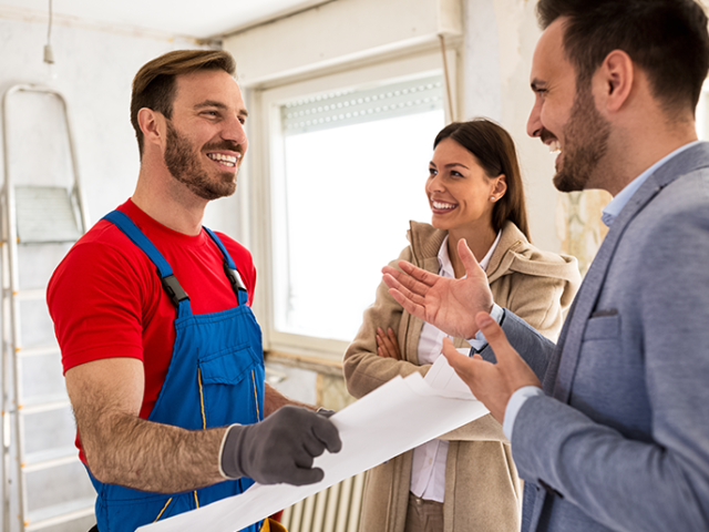Couple meets with contractor in their kitchen