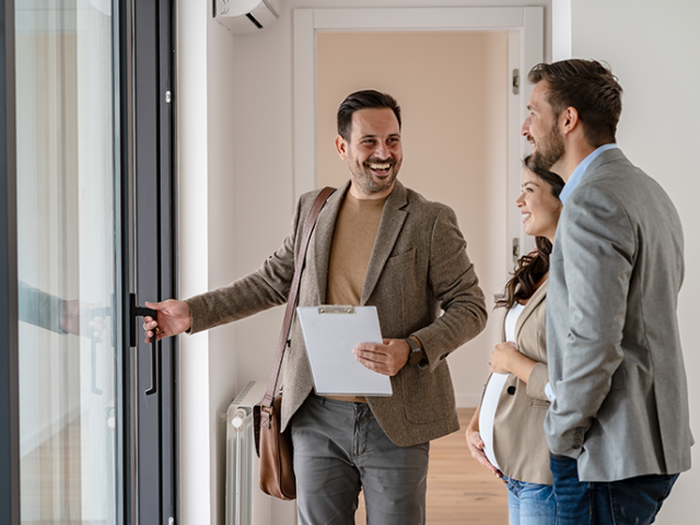 Man opening door while talking to other people