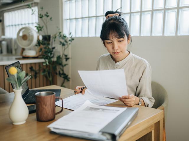 Person reviewing documents at kitchen table