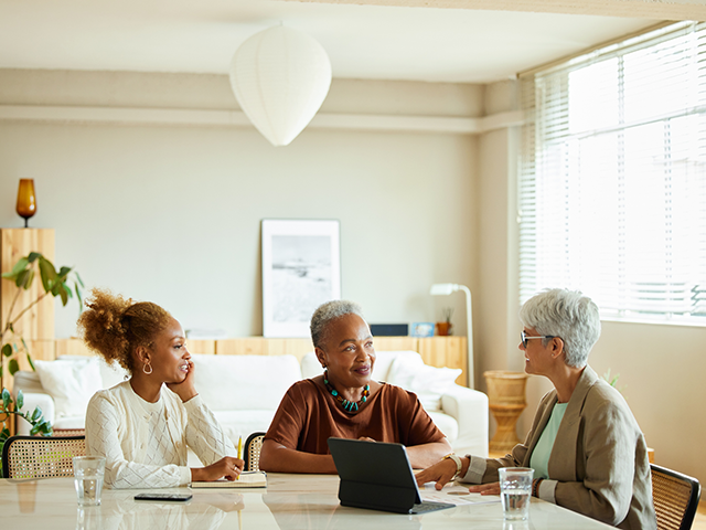 Two women meeting with their lender in an office