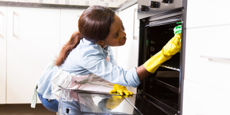 Woman cleaning kitchen appliance