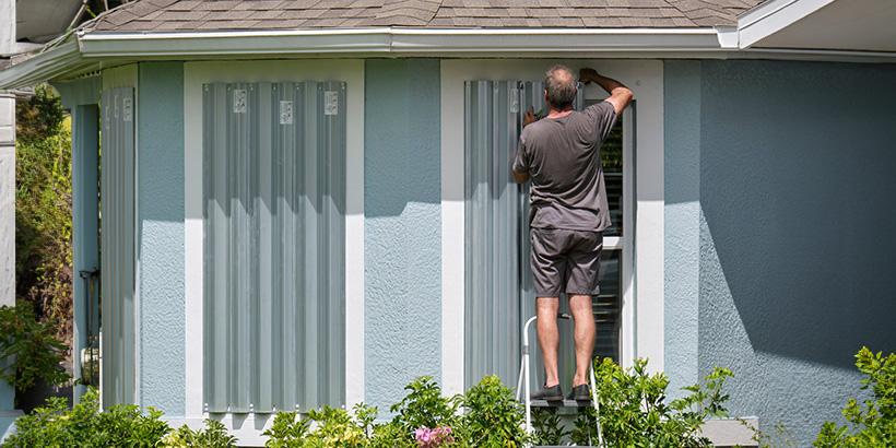Person removing storm shudders after a storm