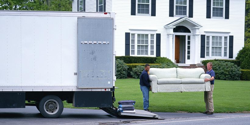 People loading furniture into a moving truck.