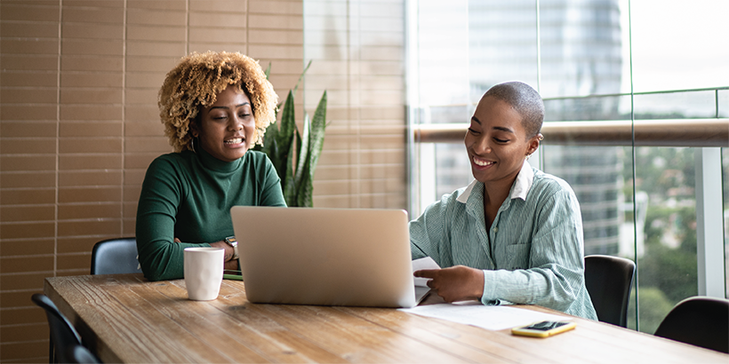 A homebuyer and lender looking at a laptop in a conference room