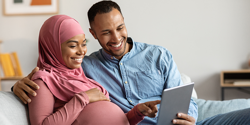 Couple on couch looking at tablet