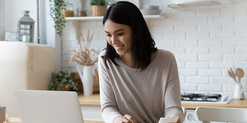 Person reviewing their finances at the kitchen counter