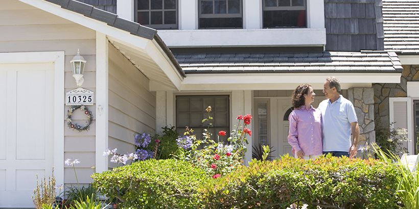 Couple standing in front of house