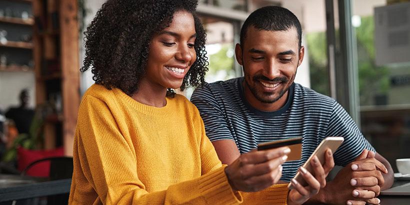 Couple using a credit card to make an online purchase