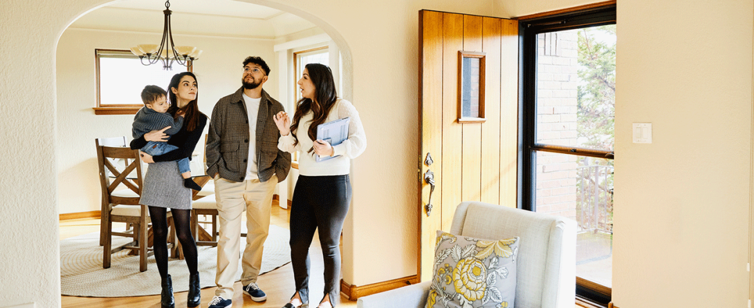 A couple with a child walking through a new house