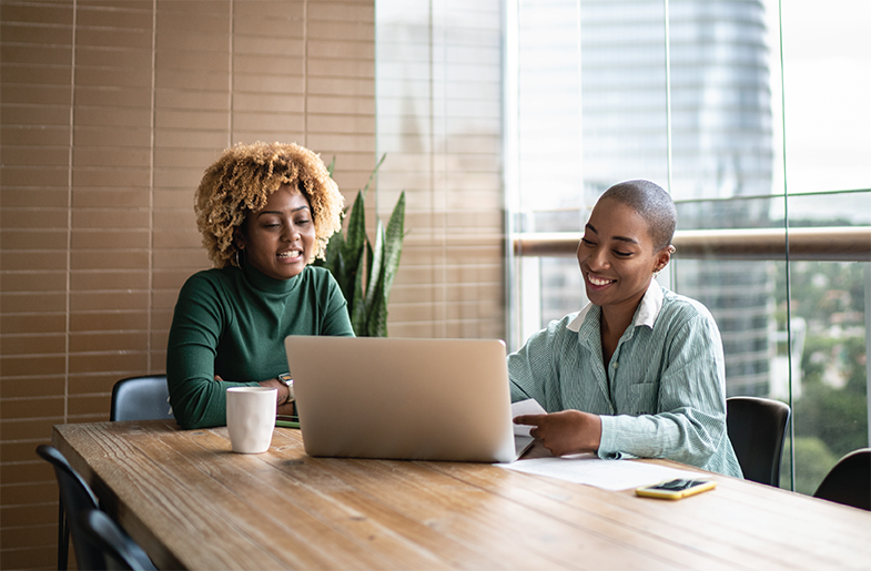 A homebuyer and lender looking at a laptop in a conference room