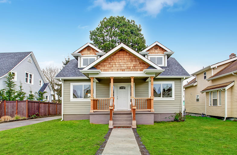 Small home with walkway leading to steps up to the front door