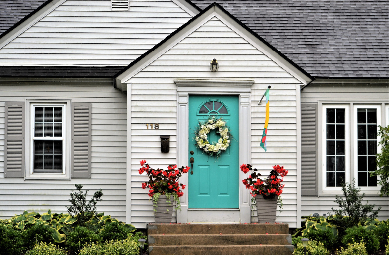 Inviting front porch with potted plants and a wreath on the door