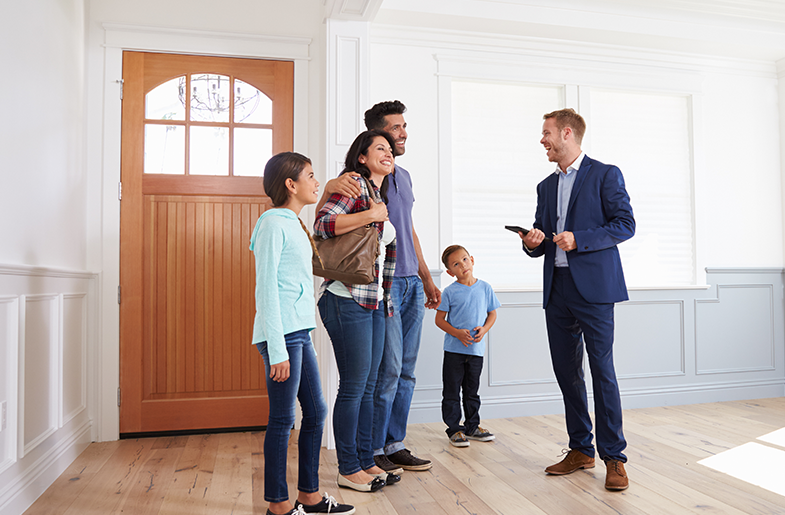 Man and family standing in the entry of a home