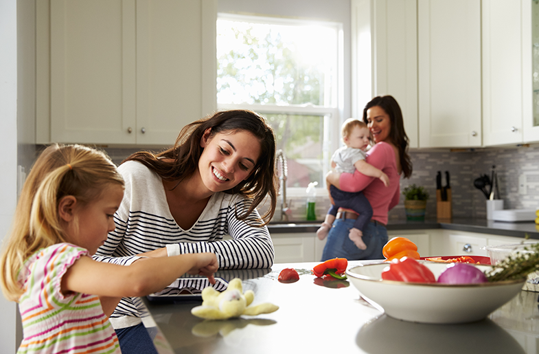 Two women in the kitchen with children