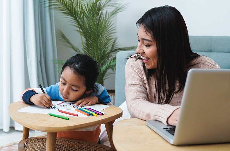Adult watches child coloring in the living room