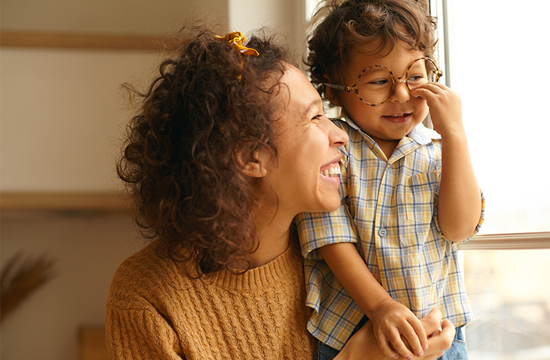 Parent holding child in front of a window