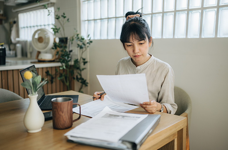 Person reviewing documents at kitchen table