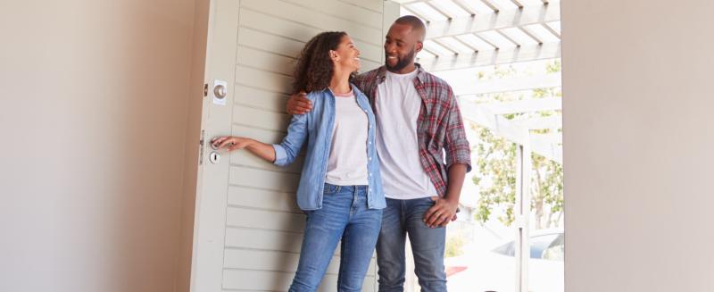 man and woman walking into a house