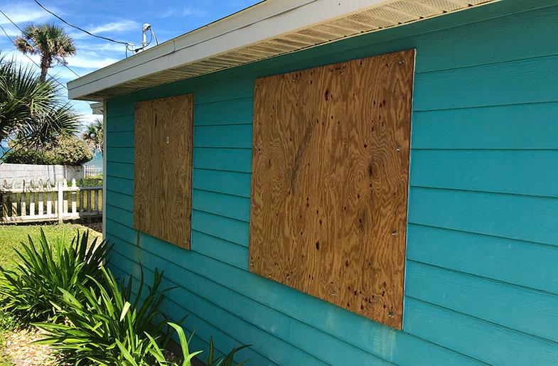 One story home with windows boarded up prior to a storm.