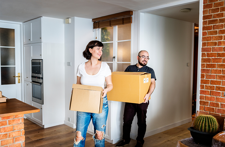 couple carrying moving boxes